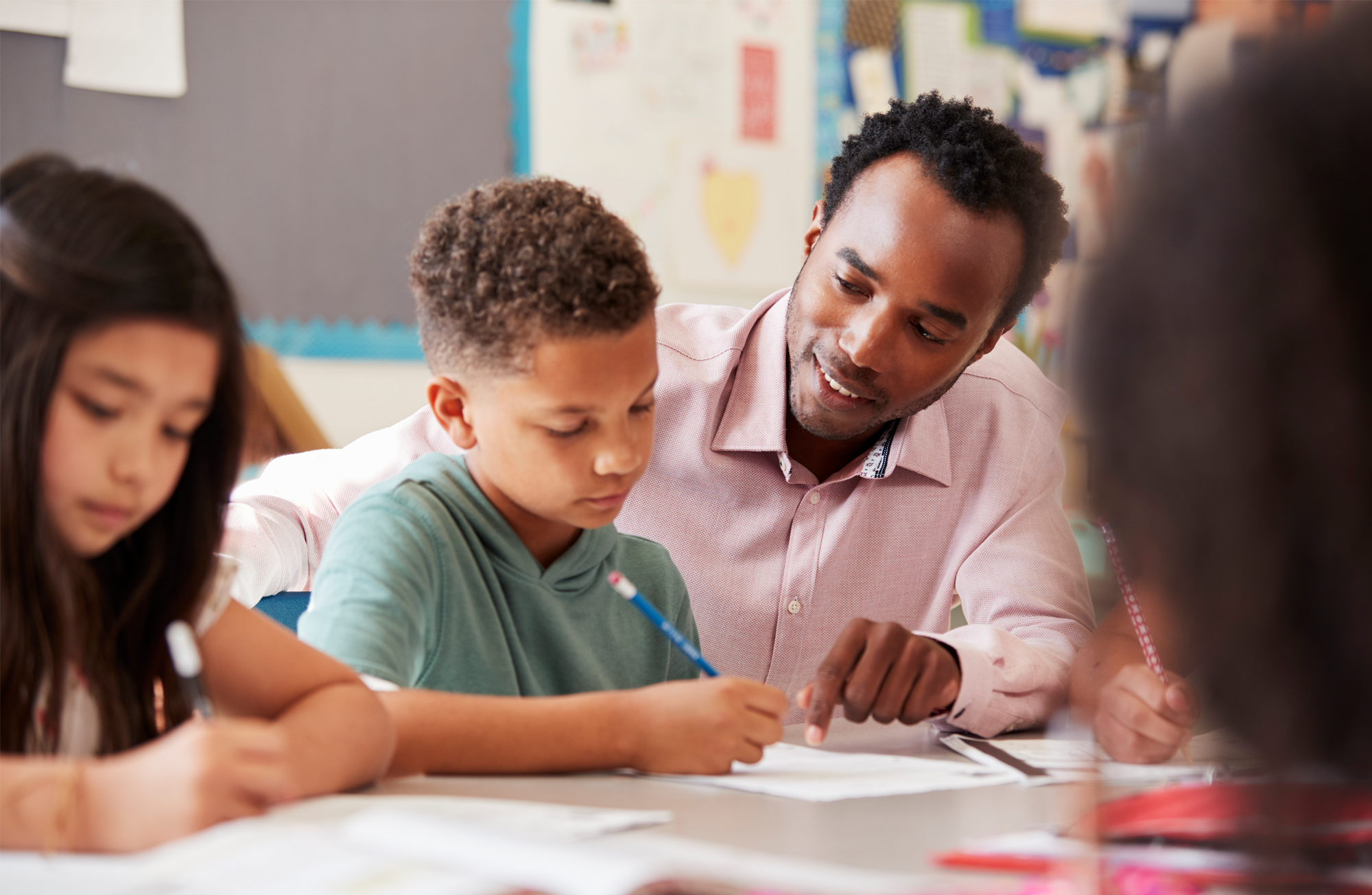 male teacher working with elementary school boy